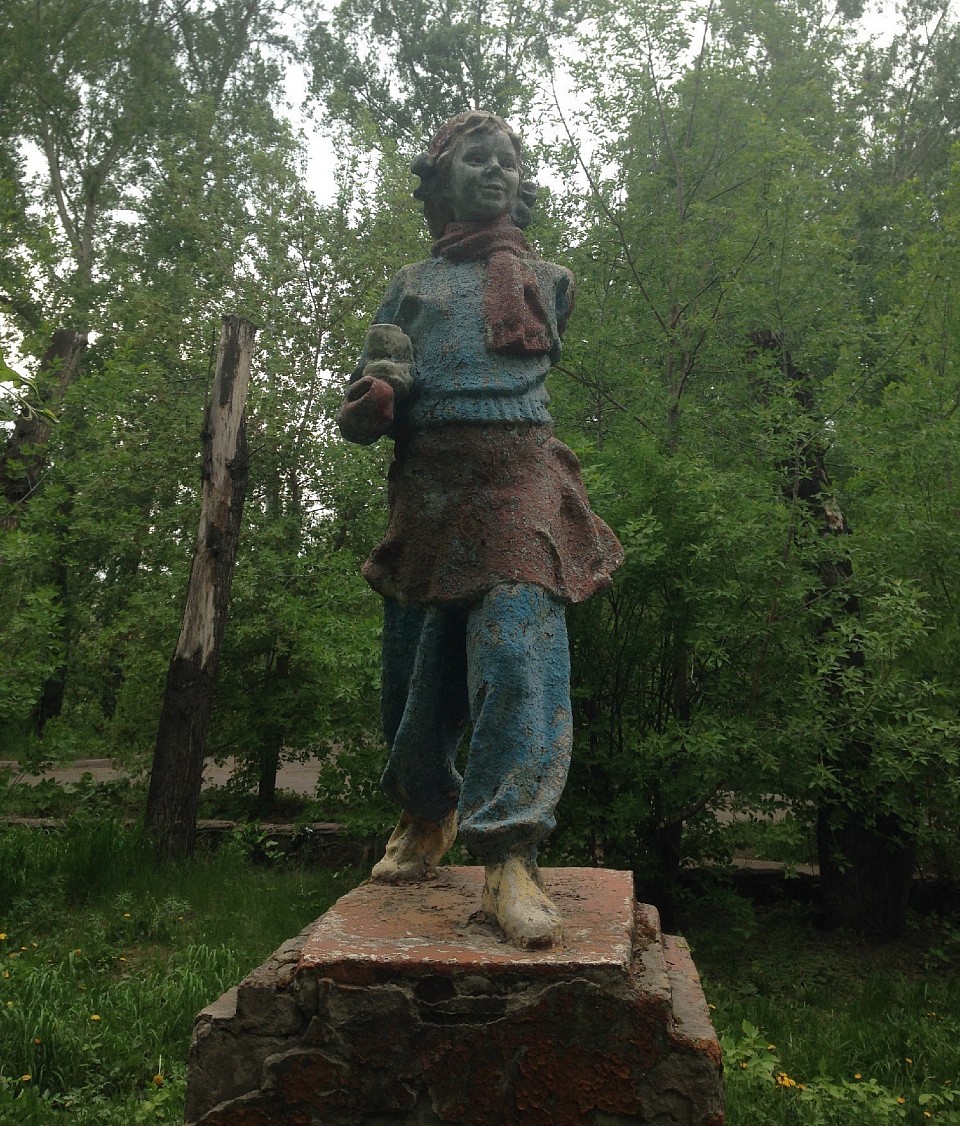 Скульптура советского времени. Девочка с одним коньком. С одним коньком потому, что одной руки у неё уже нет, увы.Стоит эта, чудом сохранившаяся девочка, в районе улиц Новая Заря и Баумана, построенных для работников полусекретного завода телевизоров, примерно в 1951-1952 годах. Уже и завода  того нет, а девчушка курносенькая стоит…
